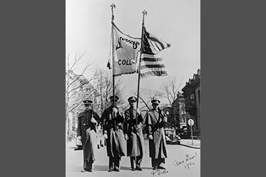 Four men in military dress holding two flags. Link to Life Stage Gift Planner Over Age 70 Situations.