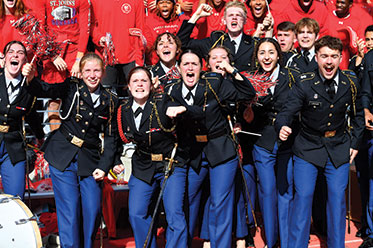 Students in military dress cheering with gusto. Links to Closely Held Business Stock