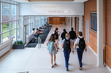 Students walking down a hallway. Links to Gifts of Life Insurance